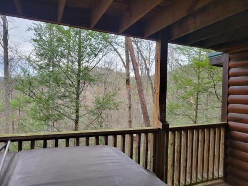 a screened in porch with a bed and a large window at Simply Charming in Pigeon Forge