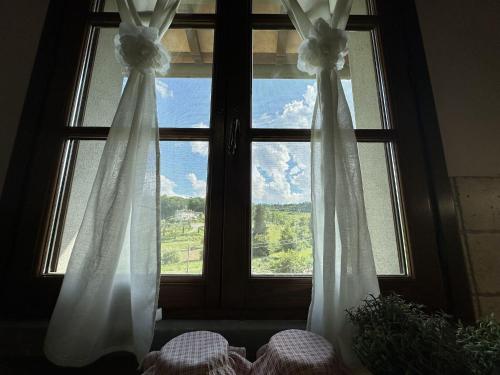 a window with white curtains and a view at Italian Experience-Dimora Palagio in Palagio