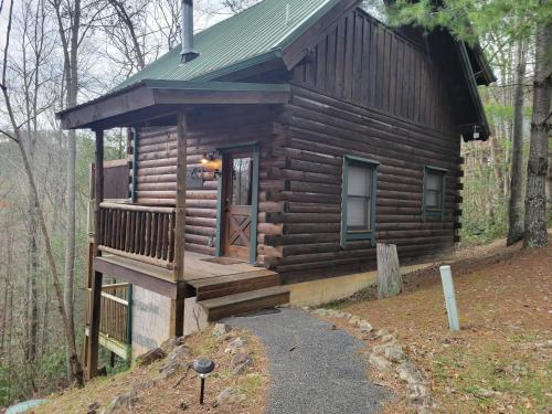 a log cabin in the woods with a porch at Simply Charming in Pigeon Forge