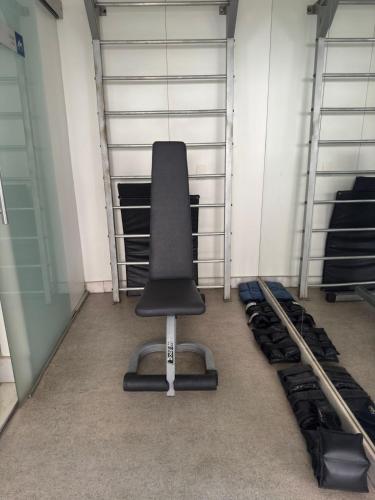 a black office chair sitting in a room with shelves at Max Savassi Glamour in Belo Horizonte