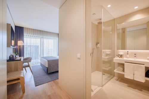 a hotel room with a bathroom with a sink and a shower at The Editory by the Sea Lagos in Lagos