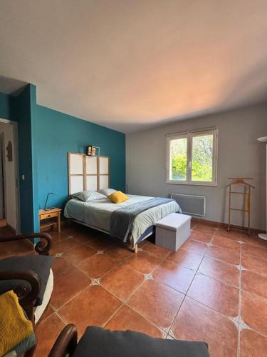 - une chambre avec un lit aux murs bleus et du carrelage dans l'établissement La maison aux oliviers, à Grasse