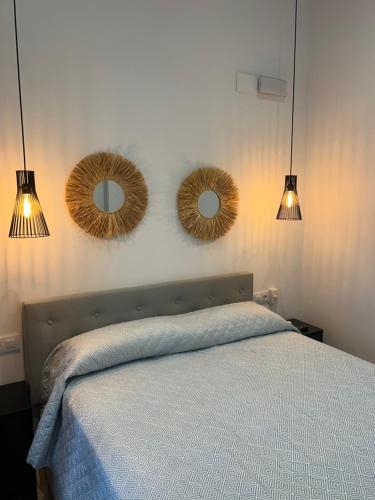 a bedroom with two mirrors above a bed at La casita de la plaza in Plasencia