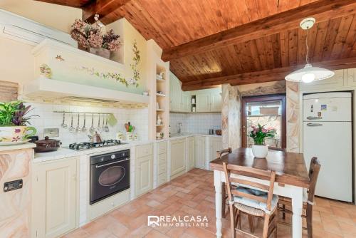 a kitchen with white cabinets and a wooden ceiling at la dimora dipinta in Luni