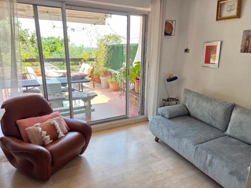 un salon avec un canapé et une terrasse dans l'établissement Charmant studio terrasse avec vue, plein sud, à Nîmes