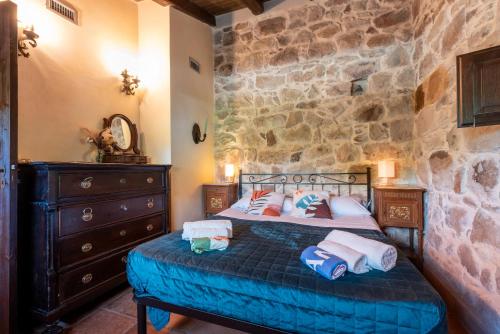Un dormitorio con una cama y una pared de piedra. en Seaside Suite In Paradise, en Cefalú