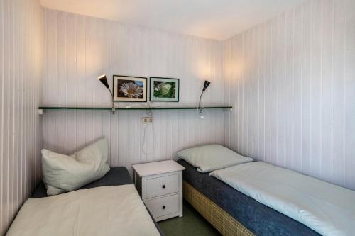 Habitación con 2 camas y mesita de noche con 2 almohadas en Möve Aba Bungalow 61, en Rerik