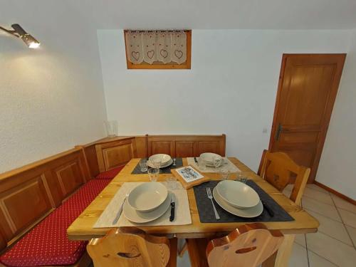 une table en bois avec des assiettes et des bols dans l'établissement Charmant appt 2 pièces, 6 pers, centre, animaux permis, ménage inclus - FR-1-241-111, au Grand-Bornand