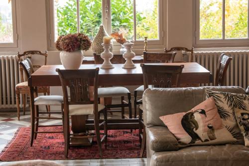 - une salle à manger avec une table, des chaises et un canapé dans l'établissement La croix des Rameaux- charming house near Lyon, à Saint-Didier-au-Mont-dʼOr