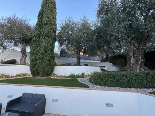 une chaise noire dans un jardin avec des arbres dans l'établissement Colocation de Vacances, à Saint-Martin-du-Var