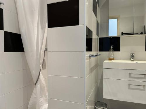 une salle de bain blanche avec un lavabo et un miroir dans l'établissement Appartement 3 pièces 4 couchages avec parking au Lavandou - FR-1-251-316, au Lavandou
