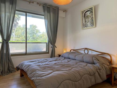 une chambre avec un lit et une grande fenêtre dans l'établissement Appartement 3 pièces 4 couchages avec parking au Lavandou - FR-1-251-316, au Lavandou