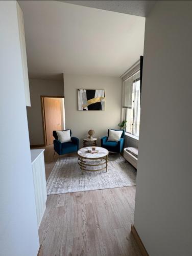 a living room with blue chairs and a table at Historic Charm meet Modern Amenities in Tacoma