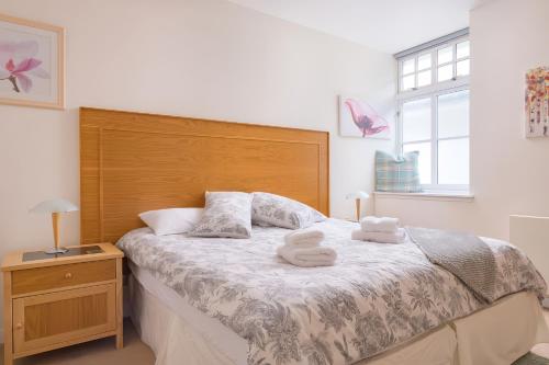 a bedroom with a bed with two towels on it at Gairn Apartment in Ballater