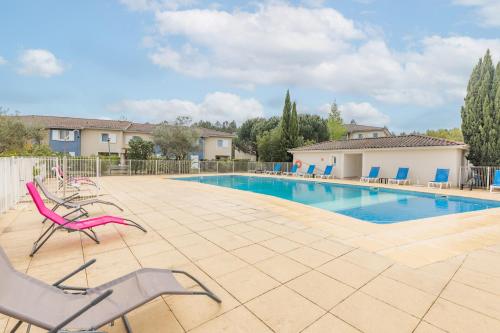 - une piscine avec des chaises sur la terrasse dans l'établissement Appart'City Classic Bordeaux Aéroport St Jean D'Illac, à Saint-Jean-dʼIllac