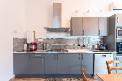 a kitchen with blue cabinets and a counter top at Gite en Campagne Léonie in Avignon