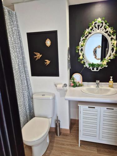 une salle de bain avec toilettes, lavabo et miroir dans l'établissement L'Eden - Premium Suite - Vue - Balcon, à Lourdes