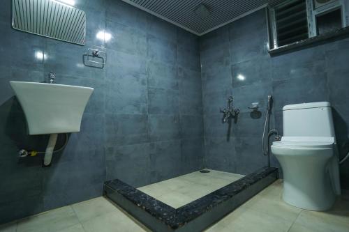 a bathroom with a toilet and a sink at Casa de Selas - A Chalet Stay in Coonoor