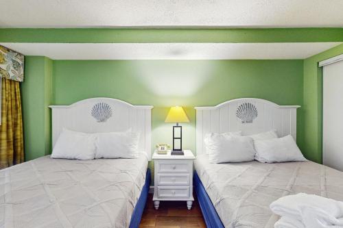 two beds in a room with green walls at Monterey Bay 617 in Myrtle Beach