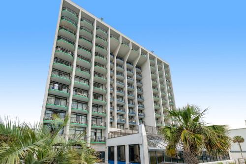 a tall white building with palm trees in front of it at Monterey Bay 617 in Myrtle Beach