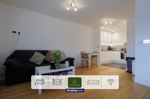 a living room with a black couch and a table at One Bedroom Apartment By Arhouse Apartments Short Lets & Serviced Accommodation Kingston With Free WiFi in Kingston upon Thames