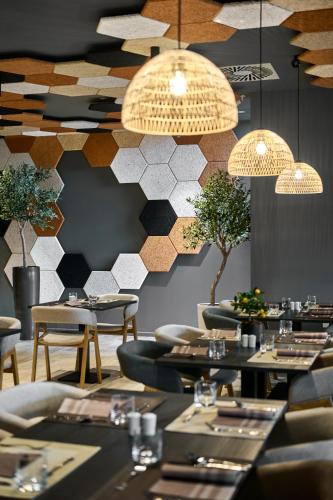 a restaurant with tables and chairs and a patterned wall at Remisens Hotel LUCIJA in Portorož
