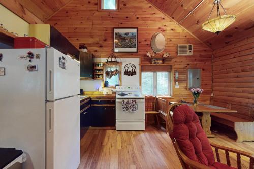 a kitchen with a refrigerator and a table in a cabin at Hemlock Ridge Retreat in Belgrade Lakes