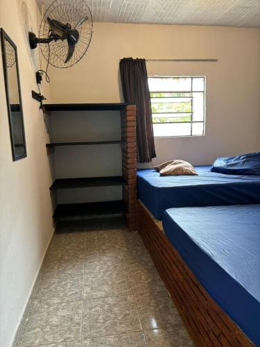 a room with two beds and a window at Casa Beira Rio in Araras