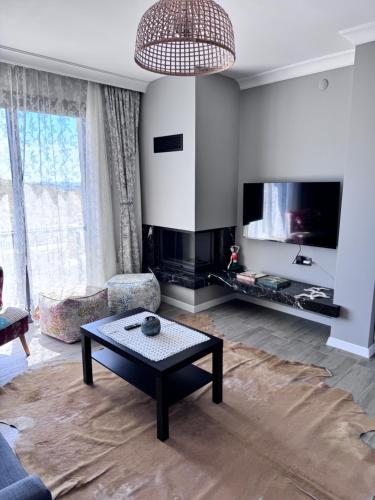 a living room with a coffee table and a tv at Villa Kataraktis in Seferihisar