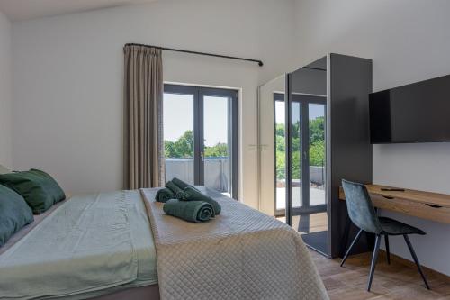 a bedroom with a bed with a desk and a television at Casa Mia in Rebići