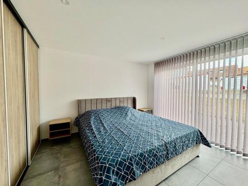 une chambre avec un lit avec une couette bleue dans l'établissement Place des Ormes 6p Apartment, à Mimizan