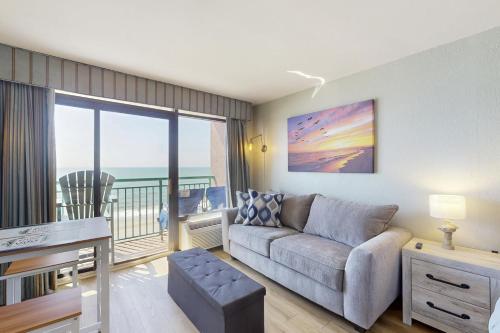 a living room with a couch and a view of the ocean at Pelicans Flight at Sandcastle South in Myrtle Beach