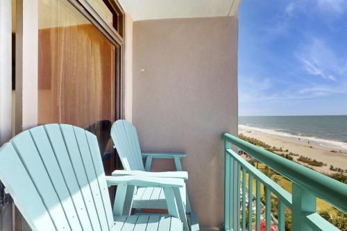 two chairs sitting on a balcony overlooking the beach at Pelicans Flight at Sandcastle South in Myrtle Beach