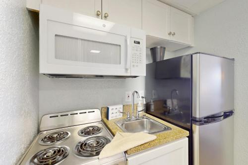 a kitchen with a sink and a microwave at Pelicans Flight at Sandcastle South in Myrtle Beach