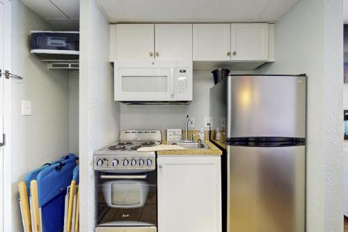 a kitchen with a stainless steel refrigerator and microwave at Pelicans Flight at Sandcastle South in Myrtle Beach