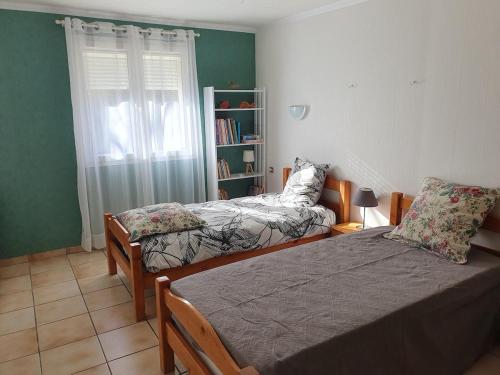 une chambre avec deux lits et une étagère dans l'établissement Maison en Cévènnes, à La Barriére