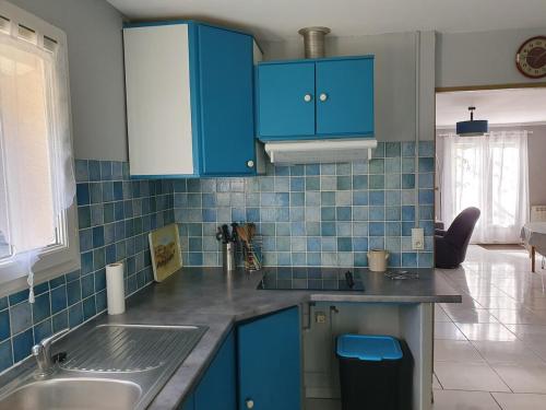 une cuisine avec des armoires bleues et un évier dans l'établissement Maison en Cévènnes, à La Barriére
