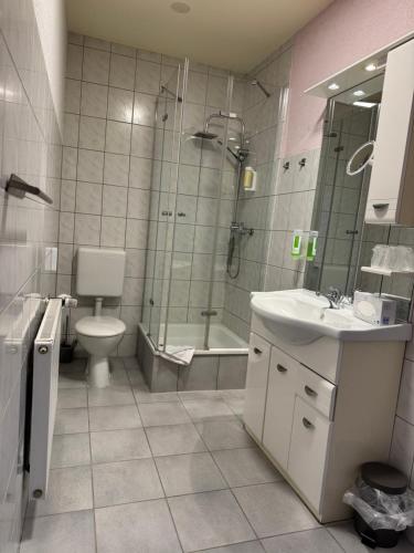 a bathroom with a toilet and a sink and a shower at Hotel-Restaurant Christine in Lübz