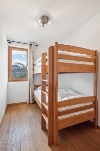 a bedroom with two bunk beds and a window at Chalet White Peak by Miggins in Grimentz