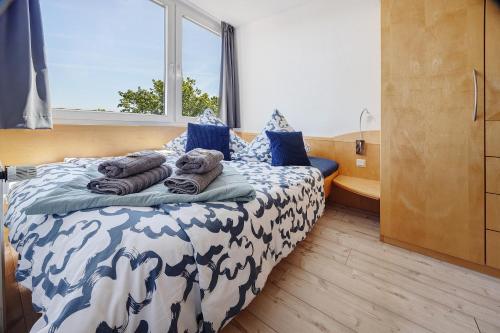 a bedroom with a bed with blue and white sheets and a window at Fräulein Frida Steinhude in Wunstorf