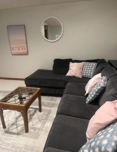 a living room with a black couch and a table at Serene single story, Grill, Fire Pit, fenced yard and Pet friendly stay in Cape May Court House