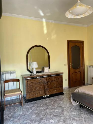 a bedroom with a dresser with a mirror and a bed at Casa Granitto in Castello del Matese
