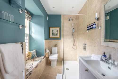 a bathroom with a toilet and a shower and a sink at The Old Millhouse - Luxury Retreat with Sauna, Cold Plunge, Yoga & Swim SPA in Dalkeith