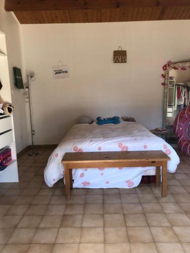- une chambre avec un lit et un banc dans l'établissement Agréable maison de vacances, à Saint-Georges-dʼOléron