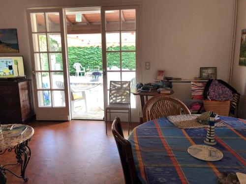 d'un salon avec une table et des chaises ainsi que d'une terrasse. dans l'établissement Agréable maison de vacances, à Saint-Georges-dʼOléron