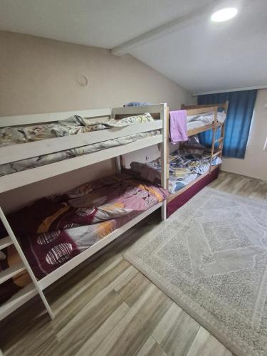 a room with two bunk beds and a rug at Arel's Home in Prizren