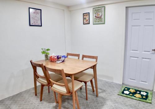 a wooden table and chairs in a room with a door at Free Netflix 3BR 10 Mins to City Center 3 Mins 7-11 in Hat Yai