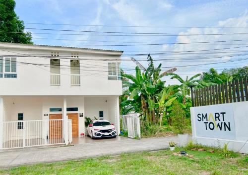 a white house with a car parked in front of it at Free Netflix 3BR 10 Mins to City Center 3 Mins 7-11 in Hat Yai