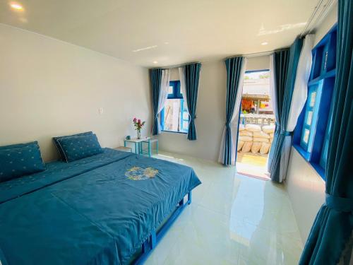 a bedroom with a blue bed with blue curtains at Biển Ngọc Homestay Đảo Bé Lý Sơn in Quang Ngai