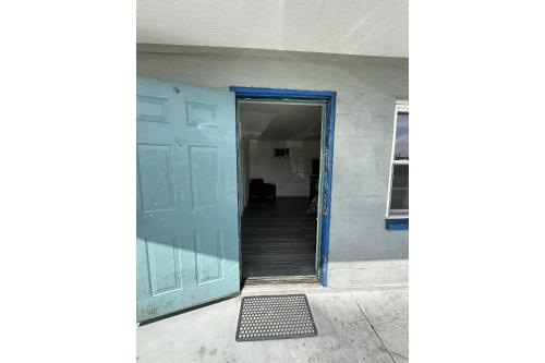 an open door of a building with a hallway at Base Motel By OYO South Tampa in Tampa